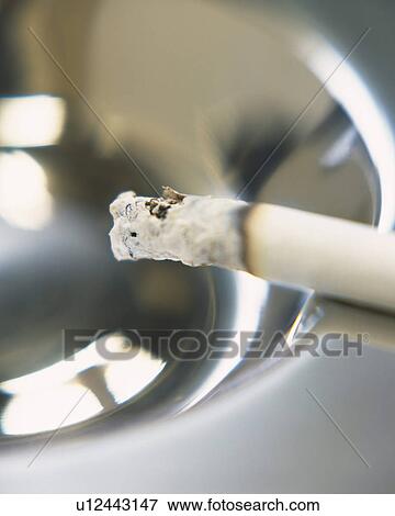 A lit cigarette on an ashtray, Close Up, High Angle View, Differential Focus View Large Photo Image Stock Photo - A lit cigarette on an ashtray, Close Up, High Angle View, Differential Focus. Fotosearch