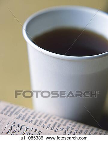 Stock Photograph - Coffee in a disposable cup and newspaper, Close Up, High Angle View, Differential Focus. Fotosearch