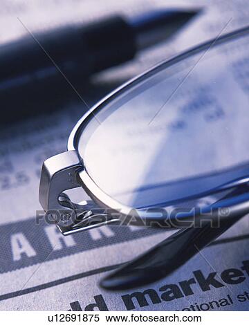 Stock Photography - Glasses and a pen on newspaper, Close Up, High Angle View, Differential Focus. Fotosearch