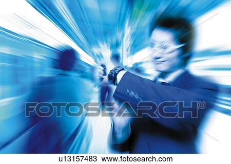 Stock Image - Young Businessman Looking Wrist Watch. Fotosearch