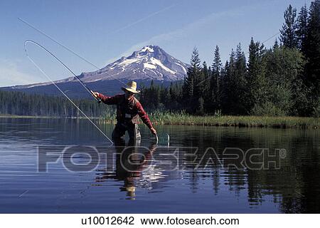Stock Image - Man Fly Fishing In Mountain River. Fotosearch