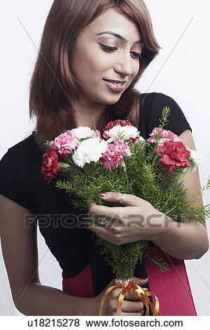 Close-up of a young woman holding a bouquet of flowers View Large Photo Image Stock Photo - Close-up of a young woman holding a bouquet of flowers. Fotosearch