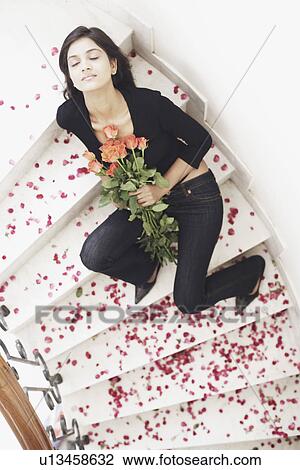 High angle view of a young woman holding a bouquet of flowers View Large Photo Image Stock Image - High angle view of a young woman holding a bouquet of flowers. Fotosearch