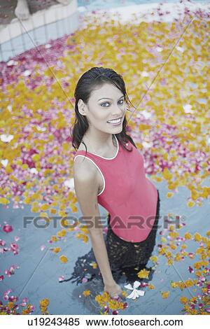 Stock Photography - High angle view of a young woman standing in a swimming pool. Fotosearch