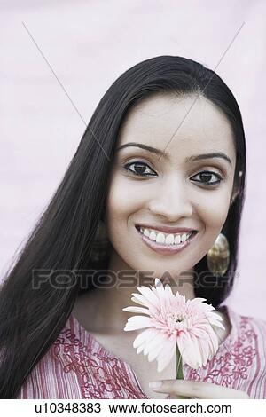 Portrait of a teenage girl holding a flower View Large Photo Image Stock Image - Portrait of a teenage girl holding a flower. Fotosearch