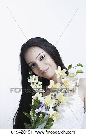 Stock Image - Portrait of a teenage girl holding a bunch of flowers. Fotosearch