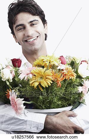 Stock Photograph - Portrait of a young man holding a bouquet of flowers. Fotosearch