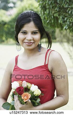 Stock Image - Portrait of a young woman holding a bouquet of flowers. Fotosearch