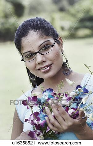 Stock Image - Portrait of a young woman holding a bouquet of flowers. Fotosearch