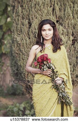 Stock Photo - Portrait of a young woman holding a bunch of flowers. Fotosearch