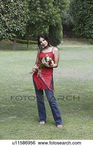 Stock Photograph - Portrait of a young woman holding a bouquet of flowers. Fotosearch