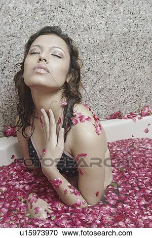 Stock Image - Portrait of a young woman in a bathtub. Fotosearch