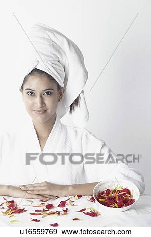 Stock Photo - Portrait of a young woman with flower petals in front of her. Fotosearch