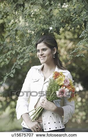 Stock Photo - Young woman holding a bouquet of flowers. Fotosearch