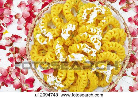 Close-up of a dish of Indian sweets with flower petals around it View Large Photo Image Stock Photo - Close-up of a dish of Indian sweets with flower petals around it. Fotosearch