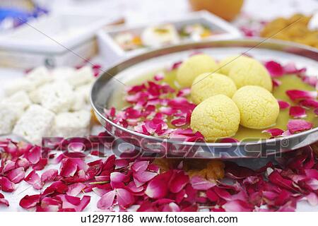 Close-up of a dish of Indian sweets with flower petals around it View Large Photo Image Stock Photograph - Close-up of a dish of Indian sweets with flower petals around it. Fotosearch