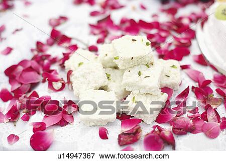 Close-up of Indian sweets on a table with flower petals around it View Large Photo Image Stock Photo - Close-up of Indian sweets on a table with flower petals around it. Fotosearch