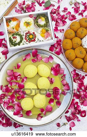 High angle view of a dish of Indian sweets with flower petals around it View Large Photo Image Stock Photo - High angle view of a dish of Indian sweets with flower petals around it. Fotosearch