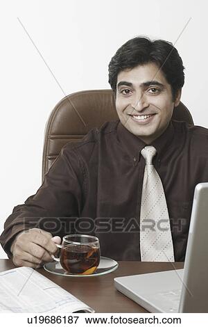 Portrait of a businessman holding a cup of black tea View Large Photo Image Stock Photo - Portrait of a businessman holding a cup of black tea. Fotosearch