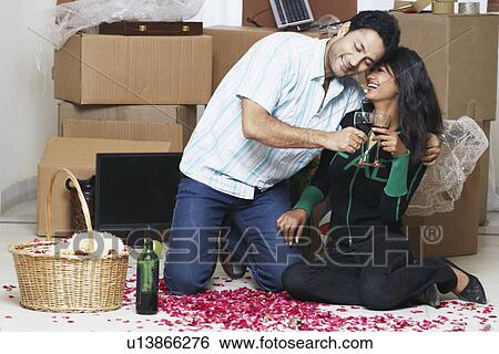 Stock Photograph - Young man kneeling with his arms around a young woman. Fotosearch