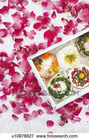 Close-up of a box of Indian sweets with flower petals around it View Large Photo Image Stock Photo - Close-up of a box of Indian sweets with flower petals around it. Fotosearch