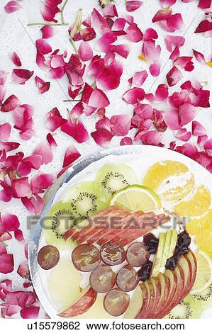 Stock Image - Close-up of a dish of salad with flower petals around it. Fotosearch