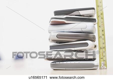 Close-up of stack of mobile phones with a tape measure View Large Photo Image Stock Image - Close-up of stack of mobile phones with a tape measure. Fotosearch
