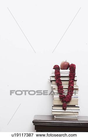 Stock Photo - Garland hanging from a stack of books. Fotosearch
