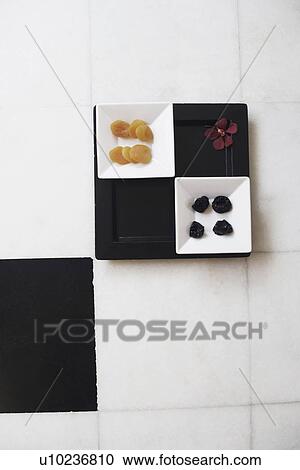 Stock Image - High angle view of dried fruits in a tray. Fotosearch