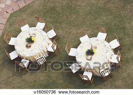 Stock Photograph - High angle view of two empty dining tables. Fotosearch