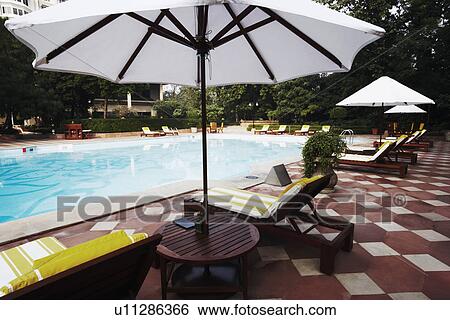 Stock Photograph - Lounge chairs at the poolside. Fotosearch