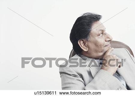 Stock Image - Close-up of a businessman with his hand on his chin. Fotosearch