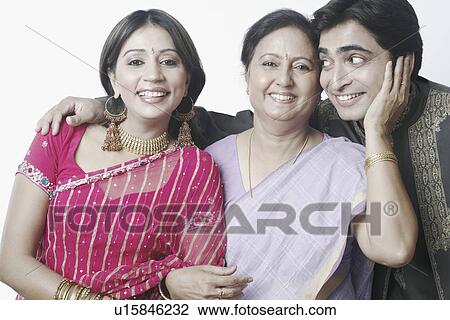 Stock Image - Close-up of a mid adult couple and a mature woman smiling. Fotosearch
