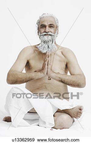 Stock Photo - Close-up of a priest sitting in a prayer position. Fotosearch