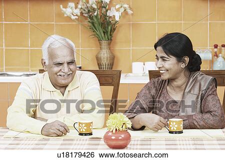 Stock Photograph - Mature couple having tea at the dining table. Fotosearch