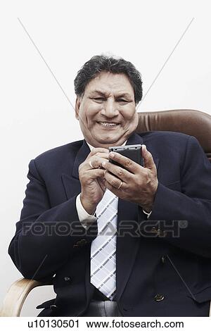 Portrait of a businessman operating a personal data assistant View Large Photo Image Stock Image - Portrait of a businessman operating a personal data assistant. Fotosearch
