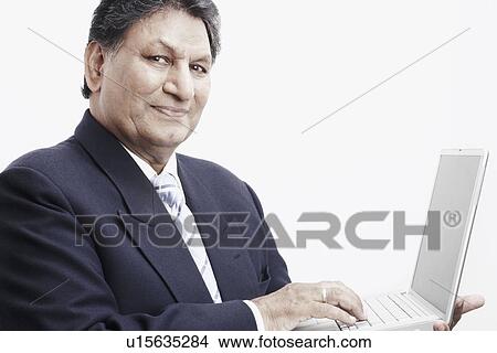 Picture - Portrait of a businessman using a laptop. Fotosearch