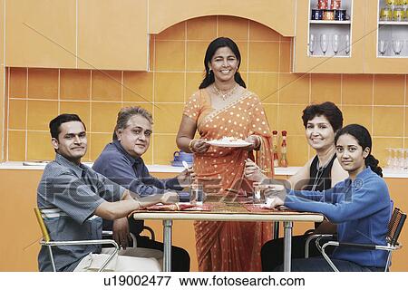 Portrait of a family sitting at the dining table View Large Photo Image Stock Photo - Portrait of a family sitting at the dining table. Fotosearch