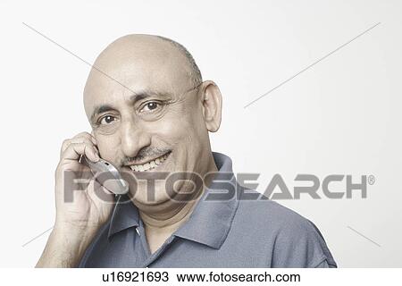 Stock Image - Portrait of a mature man talking on a mobile phone. Fotosearch