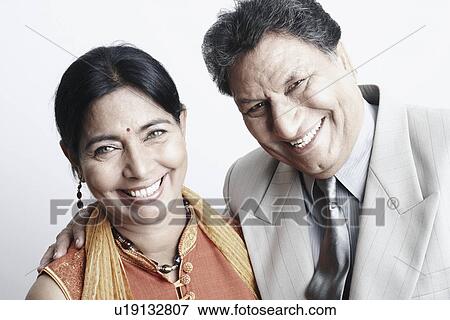 Stock Photo - Portrait of a senior man and a mature woman with arm around smiling. Fotosearch