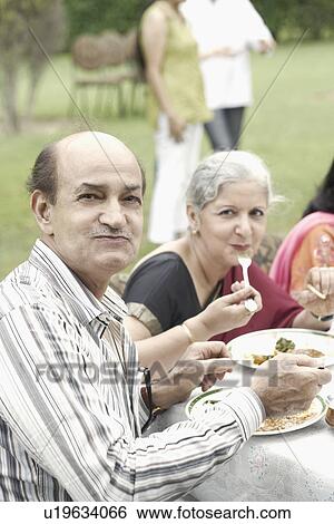 Portrait of a senior man sitting at a table outdoors View Large Photo Image Stock Photograph - Portrait of a senior man sitting at a table outdoors. Fotosearch