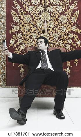 Businessman looking at a mobile phone View Large Photo Image Stock Image - Businessman looking at a mobile phone. Fotosearch