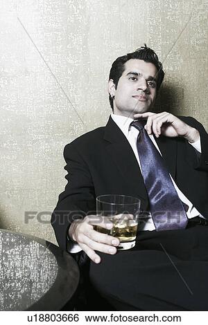 Stock Photograph - Close-up of a businessman holding a glass of whiskey. Fotosearch