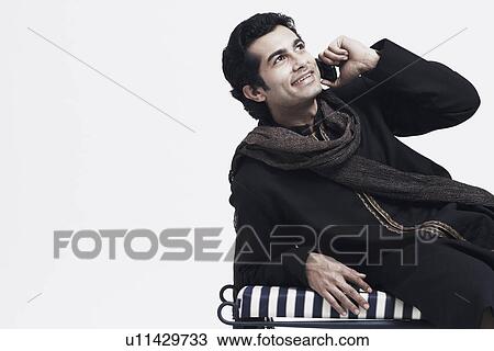 Stock Image - Close-up of a young man talking on a mobile phone. Fotosearch