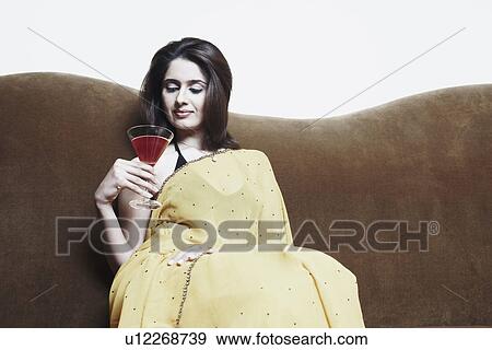 Close-up of a young woman holding a martini glass View Large Photo Image Stock Photo - Close-up of a young woman holding a martini glass. Fotosearch