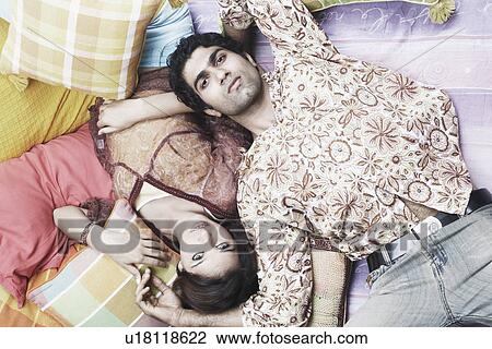 High angle view of a young couple lying down View Large Photo Image Stock Image - High angle view of a young couple lying down. Fotosearch
