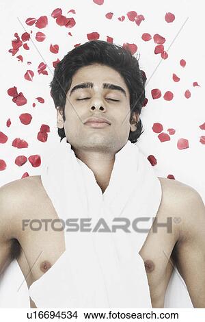 High angle view of a young man lying on a massage table View Large Photo Image Picture - High angle view of a young man lying on a massage table. Fotosearch