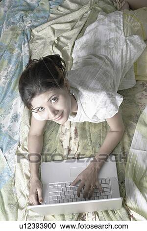High angle view of a young woman using a laptop View Large Photo Image Stock Image - High angle view of a young woman using a laptop. Fotosearch