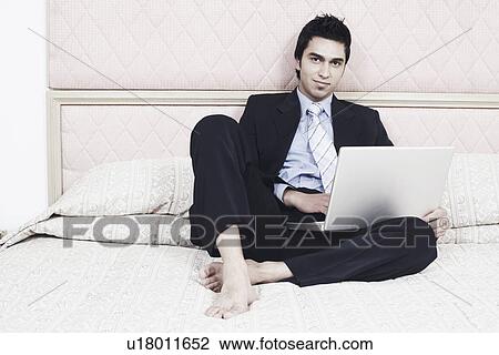 Portrait of a businessman working on a laptop View Large Photo Image Stock Image - Portrait of a businessman working on a laptop. Fotosearch