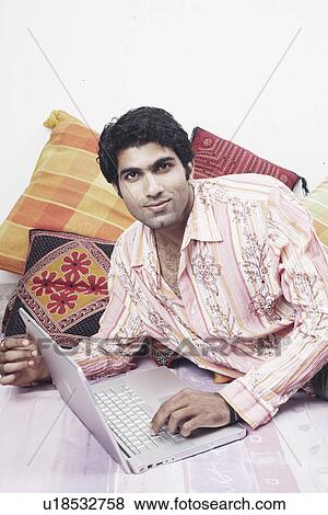 Stock Photo - Portrait of a young man using a laptop. Fotosearch